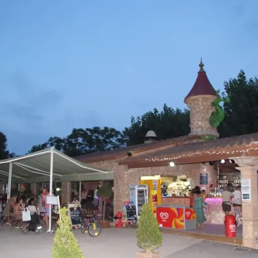 Bar ouvert à l'heure du coucher au Camping Antipolis, décoré avec guirlandes lumineuses.