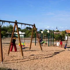 Enfants sur un parc d'attractions avec balançoires et cabane, Camping La Côte Sauvage