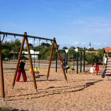 Enfants sur un parc d'attractions avec balançoires et cabane, Camping La Côte Sauvage