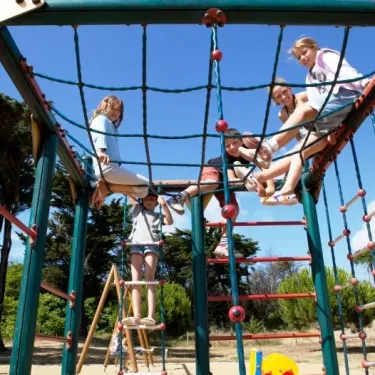 Enfants jouent sur une aire de jeux en hauteur, Camping La Côte Sauvage