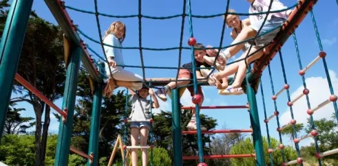 Enfants jouent sur une aire de jeux en hauteur, Camping La Côte Sauvage