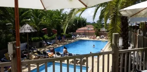 Piscine avec chaises longues et parasols au Camping Bela Basque