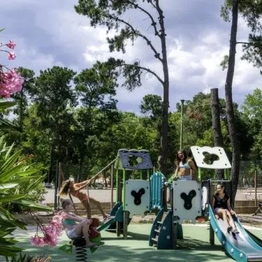 Enfants jouent sur un parc infantile dans le camping Domaine d'Anghione.