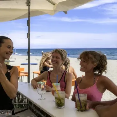 Groupes de personnes profitent d'un cocktail à la plage du camping Domaine d'Anghione.