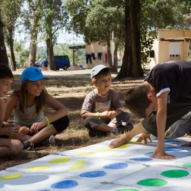 Enfants jouant au Twister sur une grande grille à Camping Domaine d'Anghione
