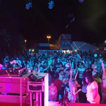 Camping Oasis Village : soirée festive avec DJ et foule dansante sous projecteurs.