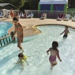 Camping Les Paludiers - Enfants qui jouent dans la piscine bordée d'un petit ponton