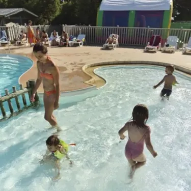 Camping Les Paludiers - Enfants qui jouent dans la piscine bordée d'un petit ponton
