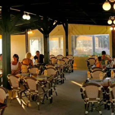 Terrasse du restaurant avec chaises à motifs dans le Camping Parc Montana