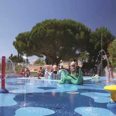 Zone de jeux aquatique avec jets d'eau et dinosaure pour enfants au Camping Parc Montana