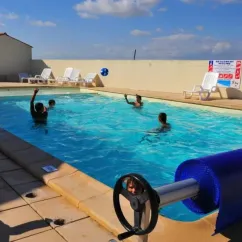 Enfants jouent au ballon dans la piscine du Camping Le Pavillon Bleu