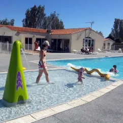 Fontaine en forme de cône vert dans la piscine du Camping Les Ilates