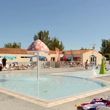 Piscine avec fontaine en forme de champignon au Camping Les Ilates