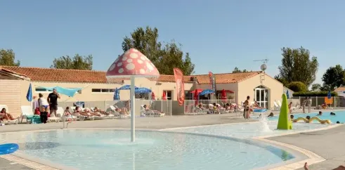 Piscine avec fontaine en forme de champignon au Camping Les Ilates