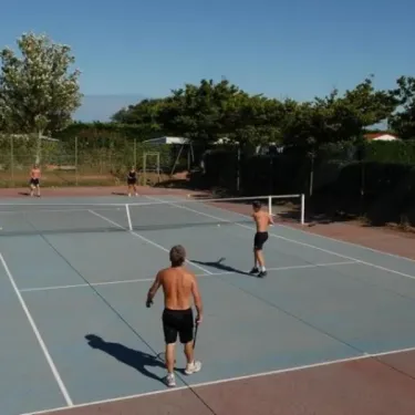 Jouer au tennis sur court extérieur Camping Les Ilates