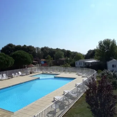 Piscine avec chaises longues et mobilier autour du Camping Résidence du Lac