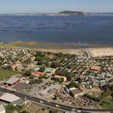 Vue aériale du Camping Beau Rivage avec piscine, chalets et plage