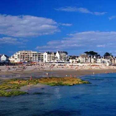 Plage animée avec bungalows et visiteurs au Camping Bois d'Amour