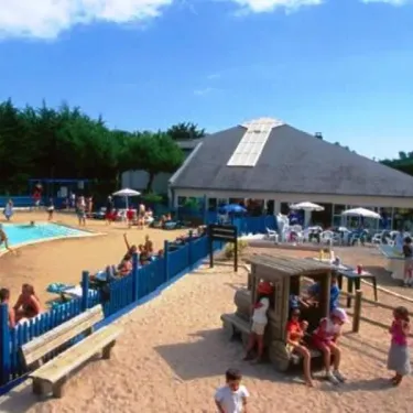 Piscine et espace détente du Camping Bois d'Amour entourés de verdure et de chaises longues.