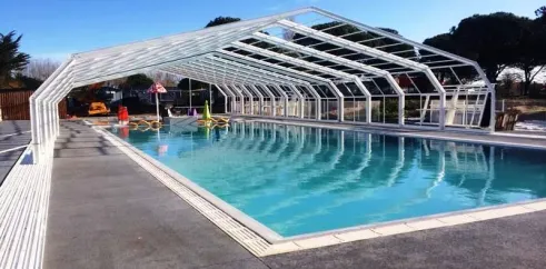 Piscine couverte au Camping Bois d'Amour sous un ciel bleu.