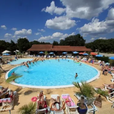 Camping Les Cigales - piscine animée avec des visiteurs et parasols colorés