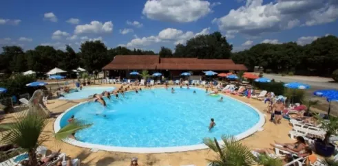 Camping Les Cigales - piscine animée avec des visiteurs et parasols colorés