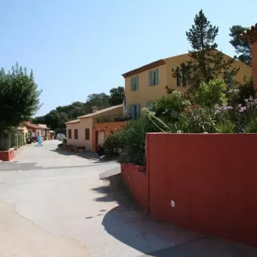 Photo camping Le Grand Calme : rue avec maison jaune et mur rouge