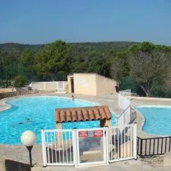 Piscine entourée de pins et de montagnes au Camping Le Grand Calme