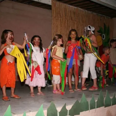 Enfants en costume coloré lors d'une représentation théâtrale au Camping Le Grand Calme