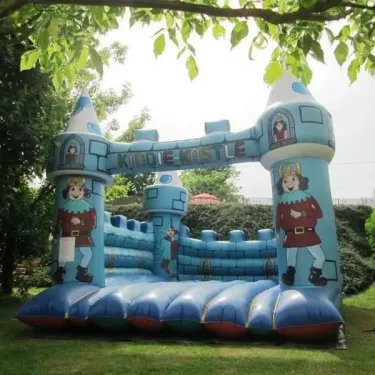Château gonflable Kiddie Kastle au Camping Le Céou, entouré d'arbres.