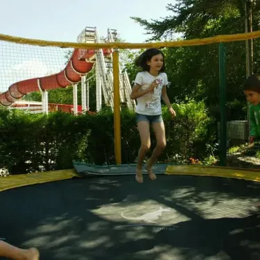 Enfants qui sautent sur un trampoline dans le parc du Camping Le Céou.