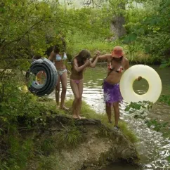Personnes avec tubes flottants près d'un petit cours d'eau au Camping Le Céou