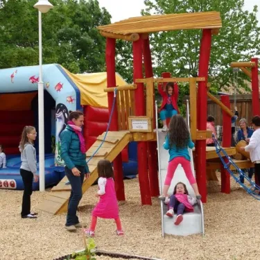Enfants jouent sur un parc infantile avec toboggan et manège gonflable au Camping La Grand Métairie