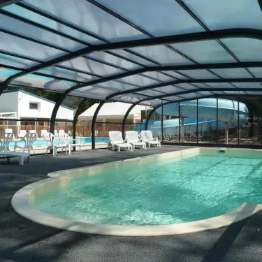 Piscine couverte avec chaises longues au Camping Les Samaras