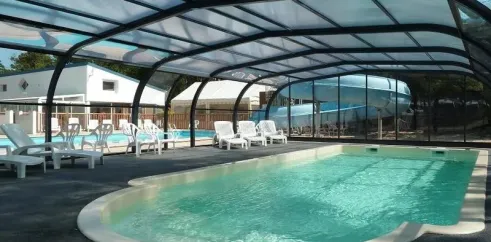 Piscine couverte avec chaises longues au Camping Les Samaras