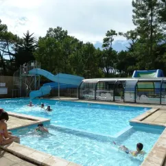 Piscine avec toboggan et enfants nageant au Camping Les Samaras
