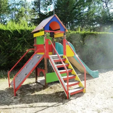 Piste de jeux colorée avec toboggans et escaliers sur sable au Camping Les Samaras.