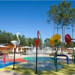 Zone aquatique pour enfants avec sculptures d'oiseaux et fleurs au Camping Fram Nature