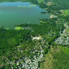 Vue aérienne du camping entouré de forêt et d'un lac, Camping Azu'Rivage