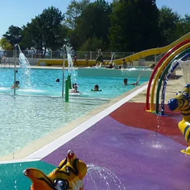 Piscine enfantine avec toboggan arc-en-ciel et animaux colorés au Camping Pipiou