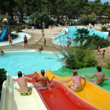 Enfants sur un toboggan coloré dans le parc aquatique du Camping La Côte d'Argent