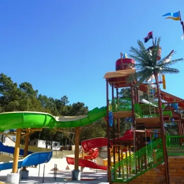 Parc aquatique avec toboggans colorés et structure de pirate au Camping La Côte d'Argent