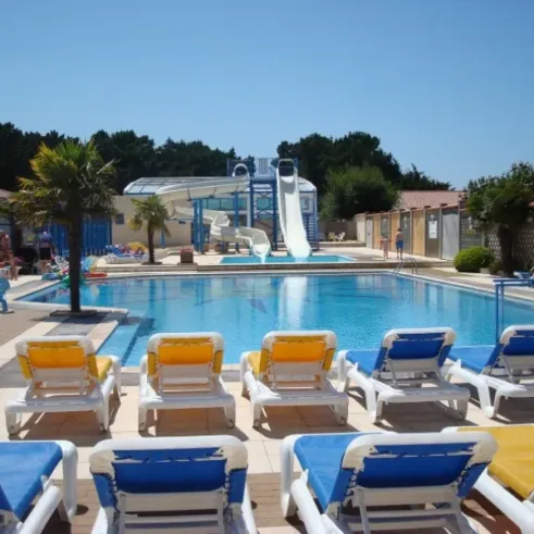 Piscine avec toboggan et chaises longues au Camping Le Chaponnet