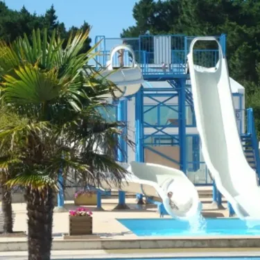 Toboggan aquatique au Camping Le Chaponnet avec palmiers et chaises longues