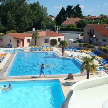 Piscine avec toboggan et chaises longues au Camping Le Chaponnet