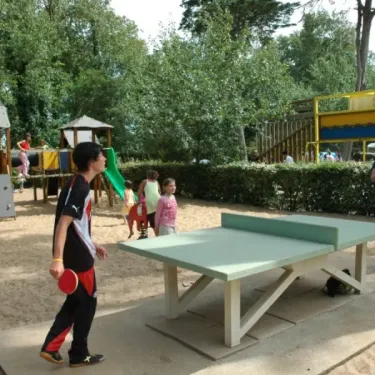 Camping Les Cyprès - enfants jouent au ping-pong dans l'aire de jeux