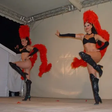Deux danseuses en costume rouge dansent sur scène au Camping Cayola