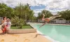 Homme sautant dans la piscine au Camping Les Amandiers