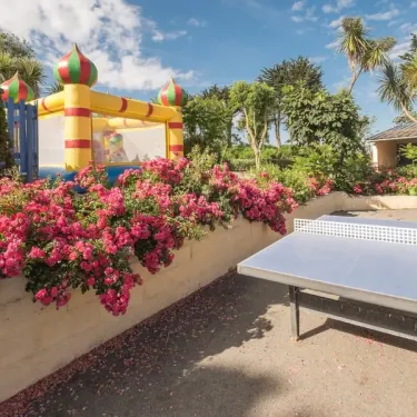 Camping Ker Vella : aire de jeux avec bounce house et table de ping-pong
