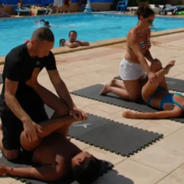 Personnes pratiquant des exercices de yoga près d'une piscine au Camping Le Lamparo